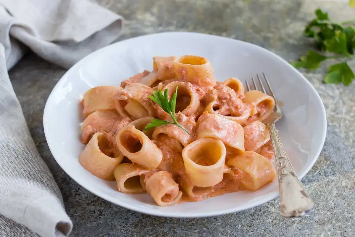 Un piatto invitante di pasta al tonno con una cremosa salsa rosa, guarnito con prezzemolo fresco.