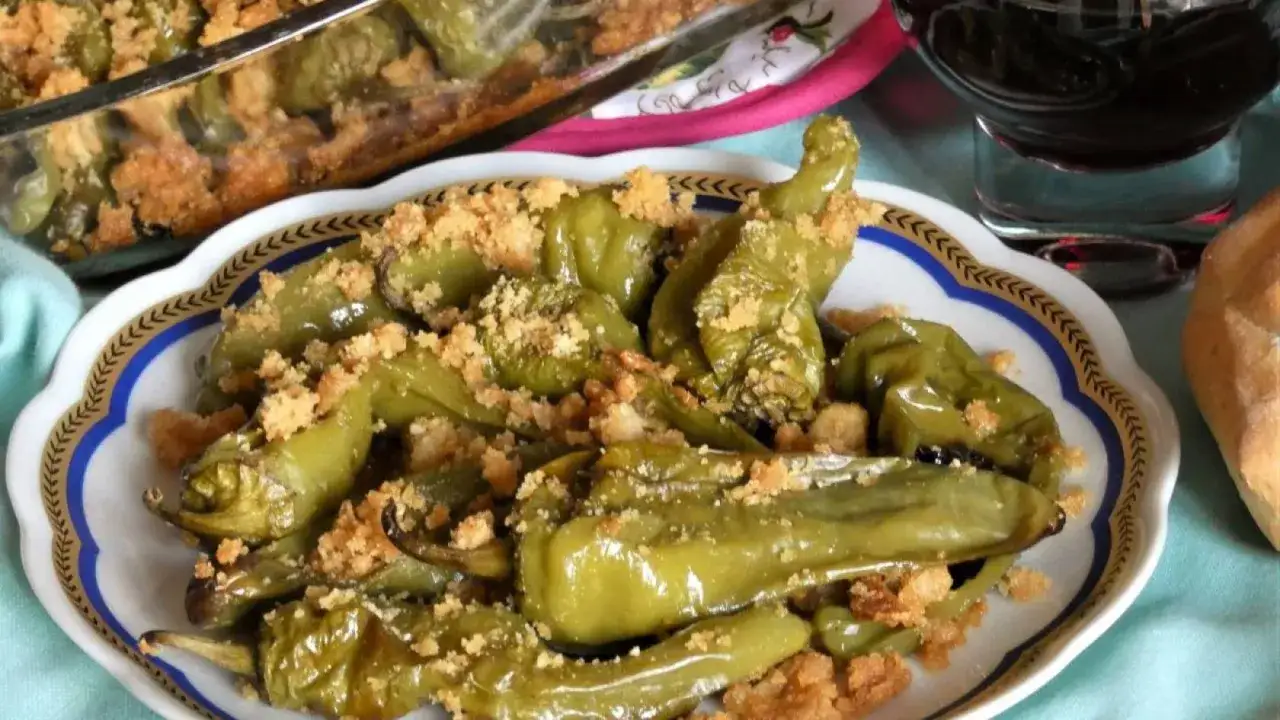 Friggitelli al forno, verdi e succosi, cosparsi di pangrattato croccante. Un contorno saporito e invitante.