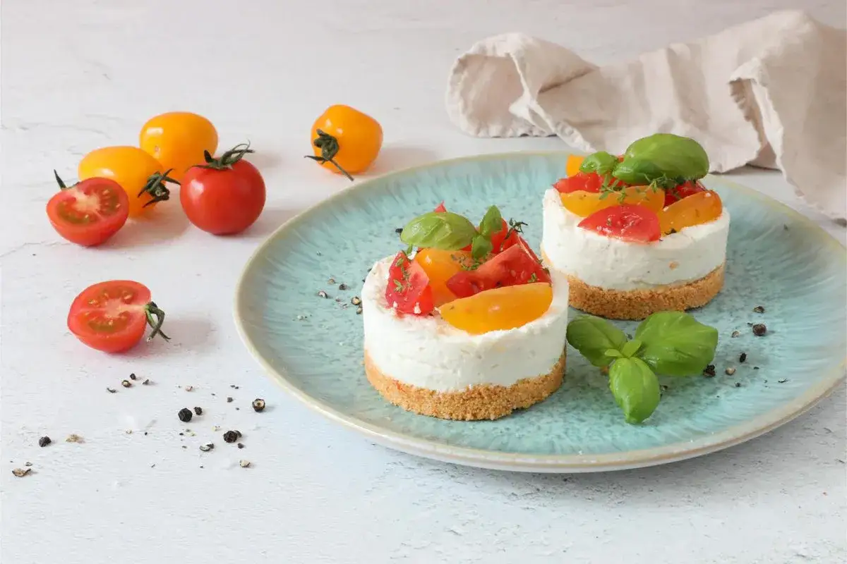 Deliziose cheesecake salate con taralli, guarnite con pomodorini colorati e basilico fresco.