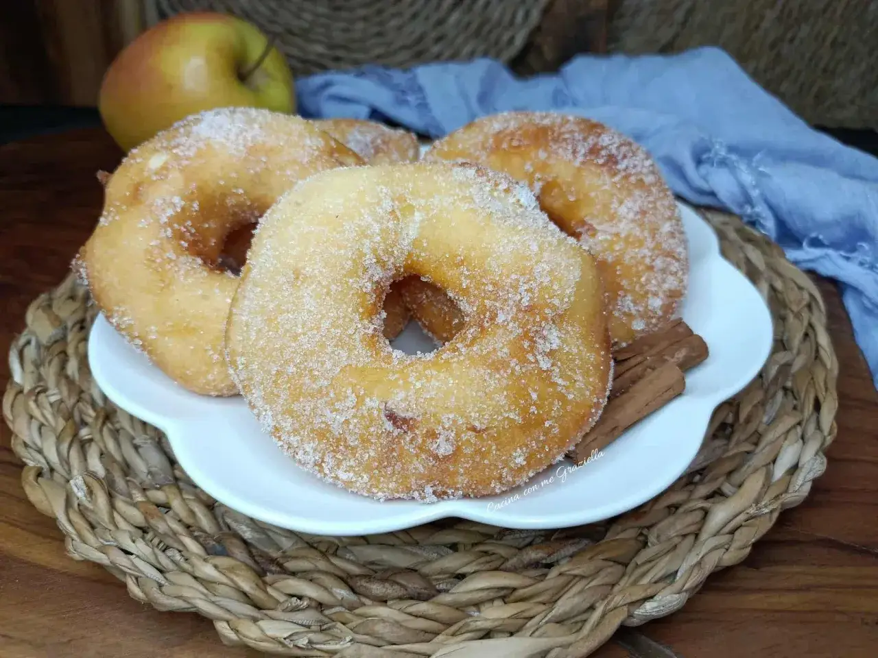 Frittelle di mele dorate e zuccherate, profumate alla cannella, pronte per essere gustate.