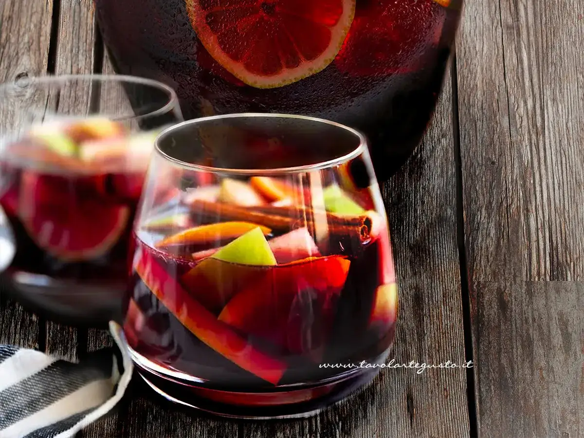 Sangria ricetta originale: bicchieri pieni di frutta fresca, cannella e vino rosso, pronti per essere gustati.